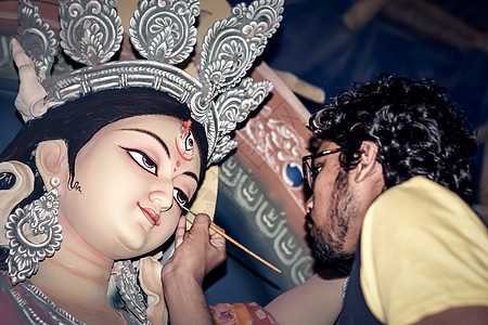 在印度教女神杜尔加的粘土偶像上画眼睛 节期间 Kumartuli 陶艺家的偶像制作过程 加尔各答 印度西孟加拉邦丙烯画艺术创造力图片
