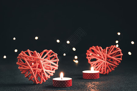浪漫的构成 - 两个心结象征爱 灯光和在黑暗桌桌上燃烧的蜡烛 情人节概念图片