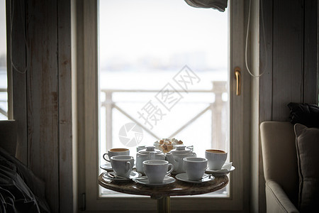 一个白茶服务站在咖啡馆桌子上的窗户上 糖弓里没有人糖厨房茶壶房子制品毛巾阳台咖啡店建筑杯子古董图片