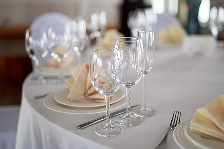 桌上的餐具 透明玻璃香槟杯 白色餐具盘 米色桃色餐巾 刀叉 没有人的桌子 没有食物的干净餐具反射午餐勺子厨房插头金属餐厅盘子服务图片