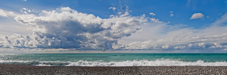 日落之日 云中天空 有海浪的蓝海 小石头海滩图片
