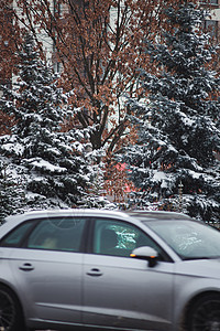 一辆汽车在下雪的冬季公路上沿着一座高楼行驶电视沥青码头驾驶线条出租车市中心交通大灯降雪图片