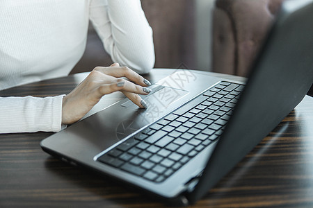 一位女士正在使用桌上的笔记本电脑工作 手在键盘上打字 女商务人士坐在咖啡馆的笔记本电脑键盘上打字男人咖啡桌面职场商业店铺电话互联图片