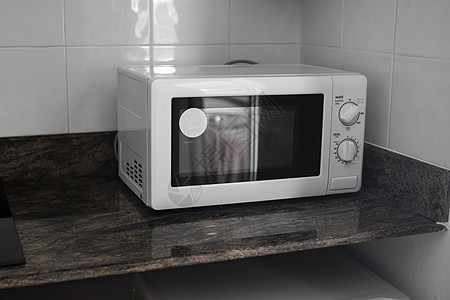 在厨房里做饭或取暖的微波炉火炉器具食物烤箱女士技术厨具按钮家庭微波图片