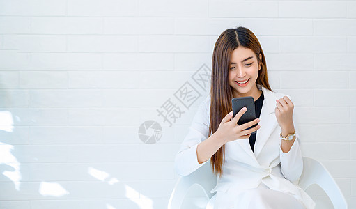 女商务人士穿白衣 乐于在白人背景下玩手机商务办公室快乐微笑商业动力电子邮件助手电脑女性图片