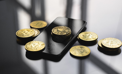 智能手机上的一叠金色 Monero 比特币硬币 桌子上有很多比特币硬币 虚拟加密货币概念 比特币在线业务的挖掘 比特币交易物物网图片
