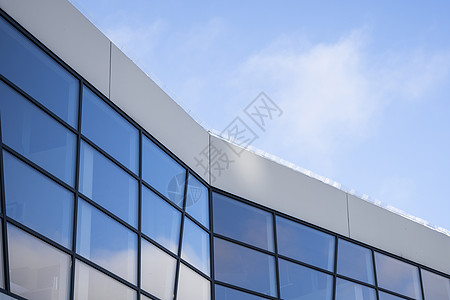 建筑物窗户中天空的倒影 蓝天上的现代玻璃摩天大楼的透视和暗角视图 营业所或公司大楼的窗户建筑工作城市市中心中心银行金融反射场景蓝图片