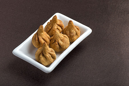 深色背景中的印度食品 Modak 马哈拉施特拉甜菜最喜欢的甘尼沙勋爵贺卡设计仪式食物宗教节日文化传统庆典盘子假期卡片图片