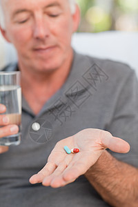 退休男人吃药沙发保险微笑房间不动产老年财产药片白色安全图片