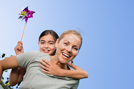 母亲和女儿带着风车父母螺旋紫色圆圈生活呼吸机女性空气家庭孩子图片