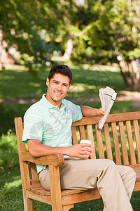 男人与报纸填字绿色植物长椅闲暇花园咖啡绿色游戏男性杯子图片