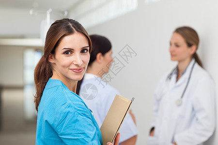 护士与一名医生和一名病人在走廊的护士 同时持有档案图片