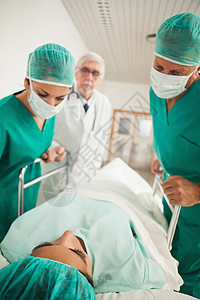 病人躺在医生旁边的医用床上图片