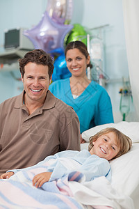 儿童躺在他父亲旁边的医学床上图片