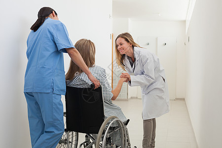 医生在护士推时和轮轮椅病人交谈图片