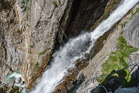 奥地利瀑布边的Via ferrata顶峰登山者攀岩悬崖铁索肾上腺素运动员登山首脑追求图片
