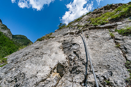 奥地利瀑布边的Via ferrata登山者铁索顶峰首脑石灰石攀岩风险爱好岩石头盔图片