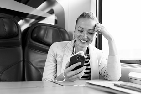 女商务人士在乘火车旅行时用移动电话进行交流乘客技术商务管理人员讲话电话工作运输互联网女性图片