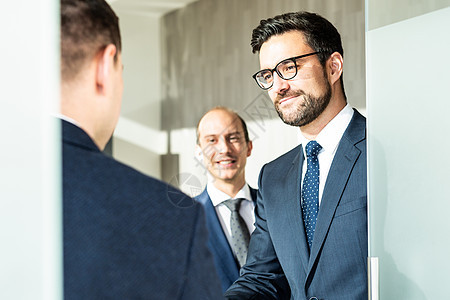 一群自信的商务人士在现代办公室的商务会议上握手致意 或通过握手达成交易协议金融合伙工作公司生意人合同人士男性律师领导者图片