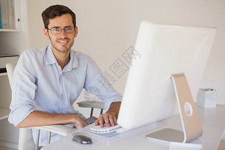 临时商务人士在桌子上对着相机微笑职业人士男性工作衬衫职场办公室胡子电脑老鼠图片