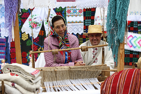 祖母在一台旧纺纱机后面工作 在旧纺车上加香料 古代捏造 女织工编织工具主食机器织物劳动女士织机纺织品操作图片