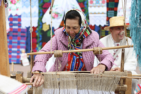 祖母在一台旧纺纱机后面工作 在旧纺车上加香料 古代捏造 女织工工具女士主食文化机器织物操作羊毛丝状纤维图片