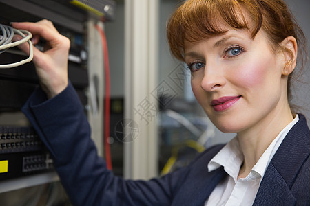 修理电线精美的计算机技师在修理服务器时对相机微笑电子产品硬件驾驶技术技术员计算诊断储物柜程序员中心背景