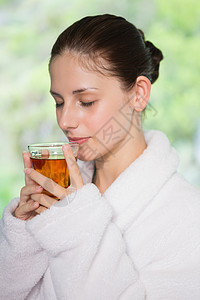 浴袍中美丽的女人在喝茶浴衣女性玻璃头发黑发眼睛热饮闲暇白色图片
