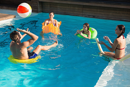 人们在游泳池里玩球的人假期男性蓝色微笑乐趣朋友混血女士闲暇友谊图片