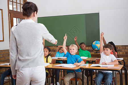 在课堂上举手的可爱学生教育小学生男性孩子职业童年笔记本女孩女性椅子图片