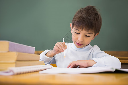 快乐的学生在书桌上写笔记本学习男生写作黑板小学生男性早教知识课堂幼儿园图片