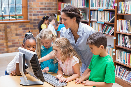 在图书馆看电脑时 学生和教师都很可爱瞳孔学校老师早教混血微笑屏幕班级图书教学图片