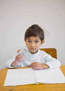 学生在书桌上用笔记本写作学校桌子男生教育绘画知识童年铅笔早教班级图片