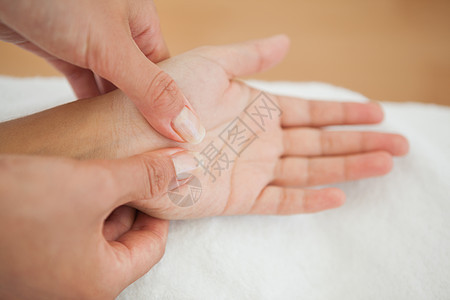 接受手按摩的女子美容穴位奢华生活方式水疗毛巾治疗身体温泉护理图片