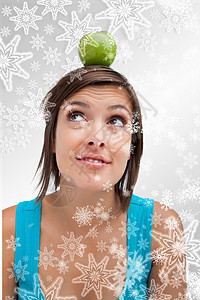 迷人年轻女性的复合形象 站立正直 头顶有绿苹果 在她头上水果雪花微笑女士假期时候绿色双手食物喜庆背景图片