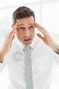 办公室有严重头痛的青年生意人男性痛苦职场领带男人双手疼痛人士衬衫偏头痛图片