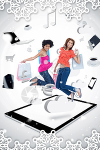 两个微笑的女人在平板电脑 p 上跳跃的合成图像女性牛仔裤友谊技术云计算触摸屏购物袋购物快乐女士图片