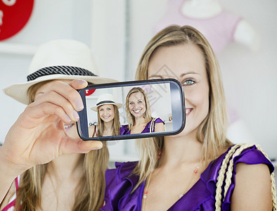 手持智能手机显示的复合图象喜悦衣服镜子电话零售店铺裙子蓝色销售女性图片