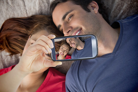 情侣在智能手机上自拍技术公园长发头发毯子喜悦微笑展示夫妻拥抱图片