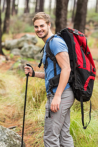 一个年轻英俊的远足者肖像活动绿色风景林地微笑闲暇男性环境森林勘探图片
