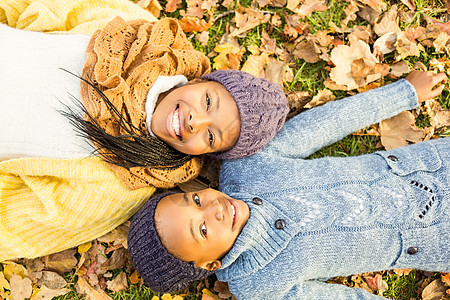 年轻母亲与女儿躺在树叶上女孩们对方女孩农村幸福快乐活动女性微笑草地图片