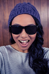 亚洲女人对着镜头微笑棕色屏幕女性女士头发快乐紫色自拍技术帽子图片