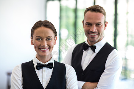等待工作人员对镜头微笑女士男性衬衫女性领结服务员快乐酒店男人马甲图片