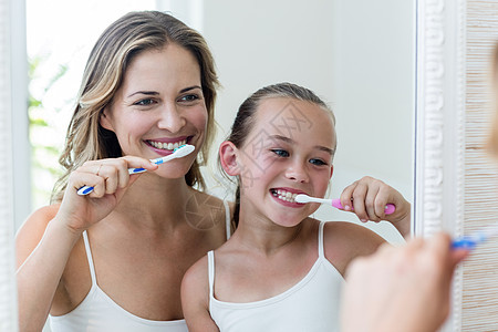母亲和女儿在洗手间刷牙牙刷亲密感快乐口腔牙科房子打扫女孩女性感情图片