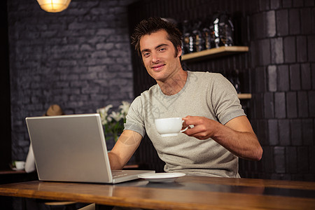 男人用笔记本电脑喝咖啡杯子男性服装活动餐厅商业花朵面包咖啡饮料图片