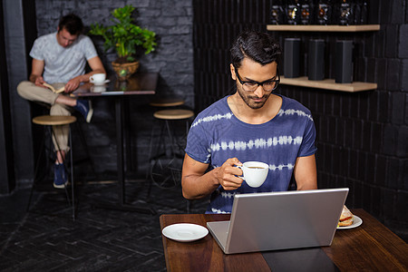 男人用笔记本电脑喝咖啡食堂商业时间活动文学杯子闲暇午餐桌子食物图片