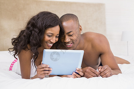 使用数字平板电脑的年轻夫妇夫妻数位板公寓男性住所互联网膀子女士家庭微笑图片