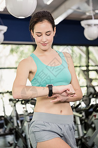 使用智能手表的妇女文胸身体健身房女士闲暇锻炼电脑训练纺纱技术图片