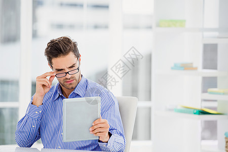 使用数字板的商务人士椅子职业人士公司职场桌子平板网络阅读眼镜图片