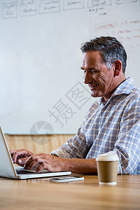 办公室内使用膝上型电脑的人商业笔记本休闲沟通手机企业家网络男性公司杯子聪明的高清图片素材